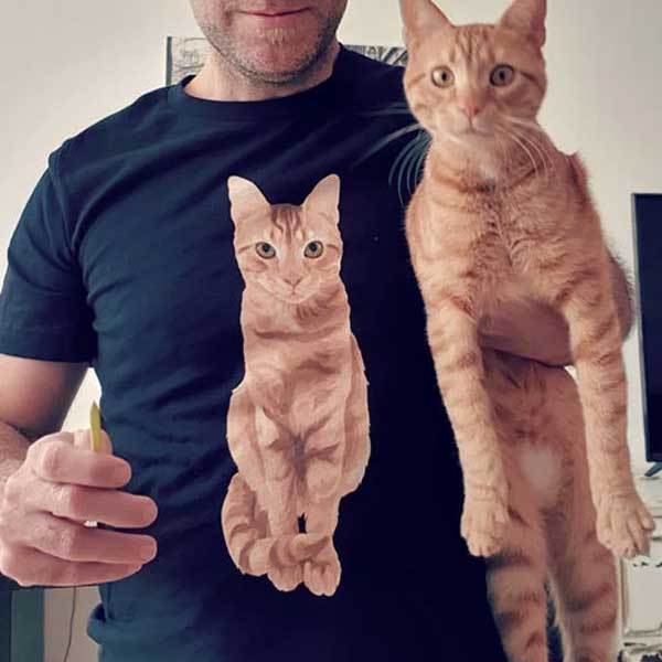 A picture of an owner who is wearing a T-shirt with a picture of his cat