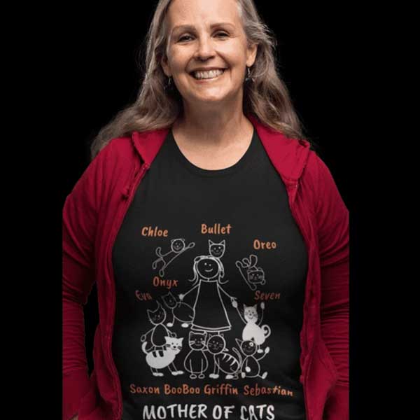 A lady who is wearing a black Tshirt with names of all her cats