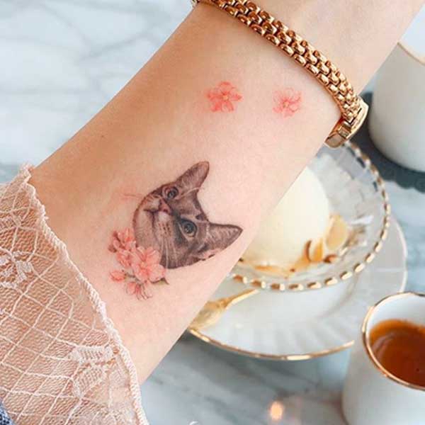 A minimalist small wrist cat tattoo by SOL