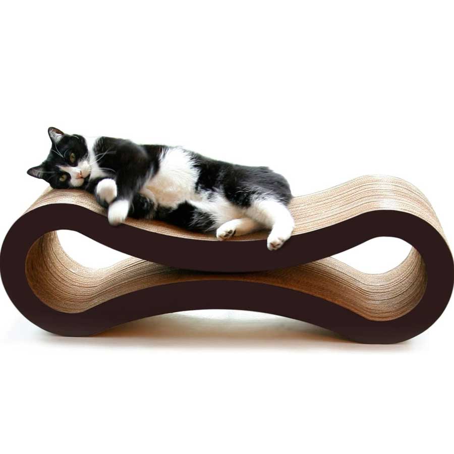 A black and white cat who is lying on PetFusion cat scratcher lounge